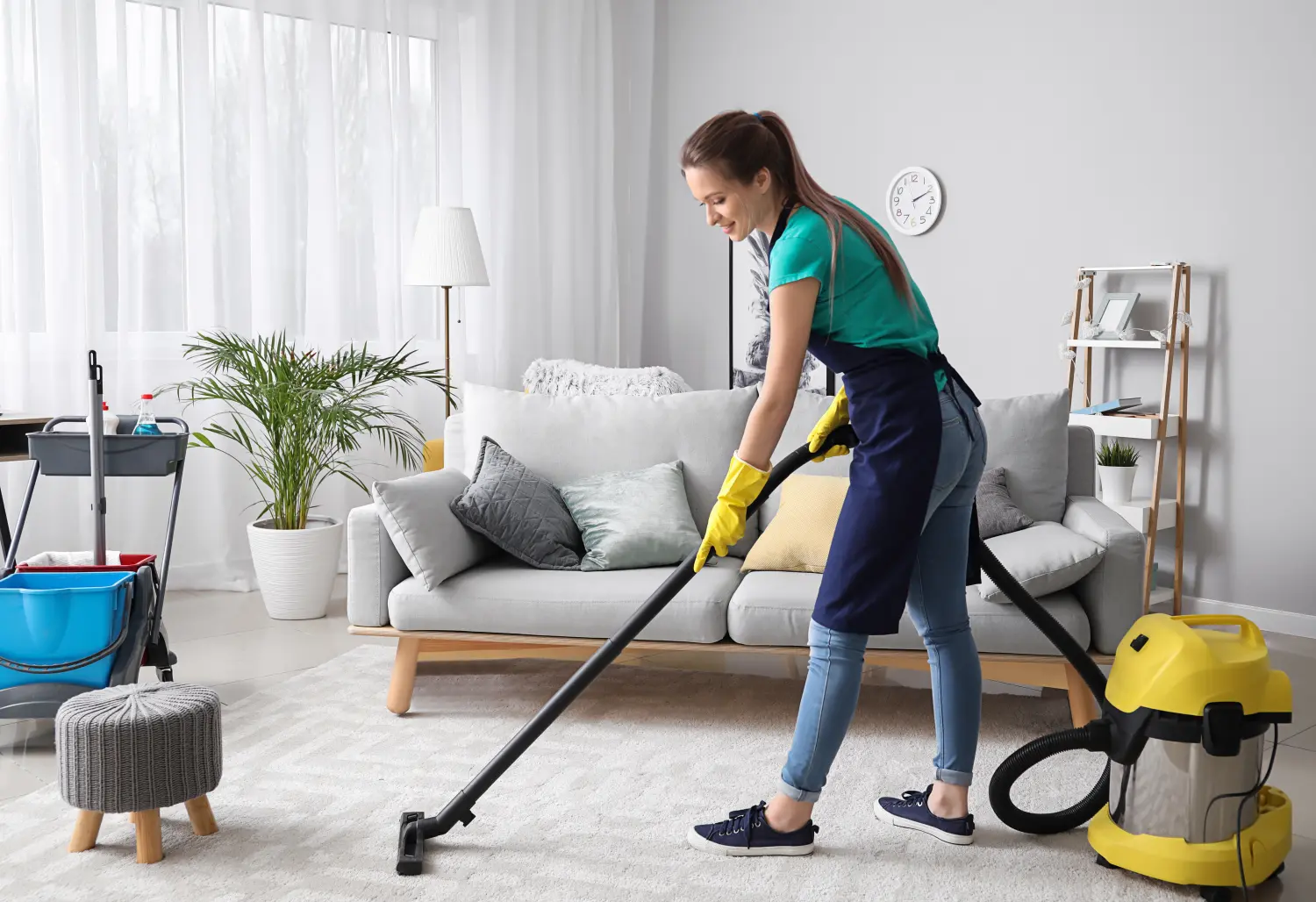 Hausmeisterin mit Staubsauger im Zimmer